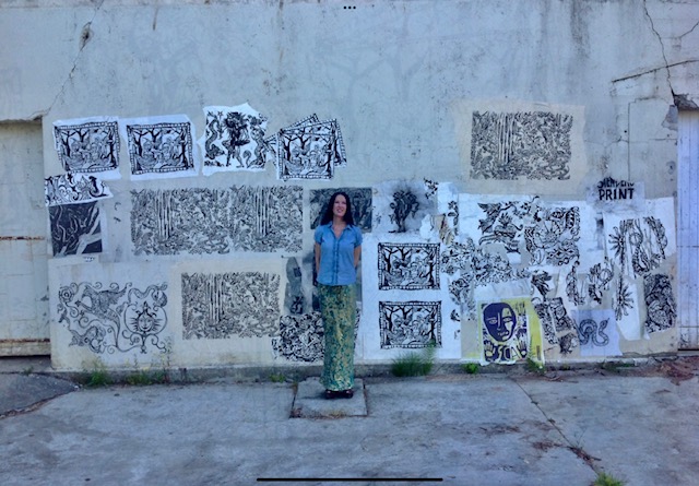Darbury in front of wall with prints.